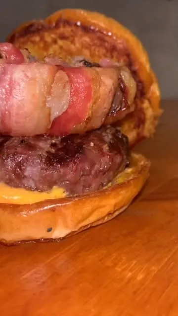 Close de burger com carne alta e bacon enrolado